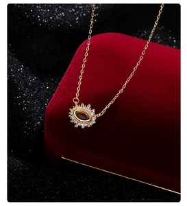 Close-up of luxury gold evil eye necklace with tiger eye stone on black glitter