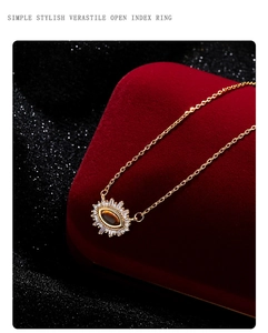 Macro detail of French luxury evil eye tiger eye pendant necklace on red velvet box
