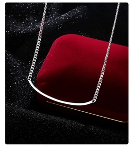 Macro shot of a silver smile pendant necklace on a red velvet jewelry gift box