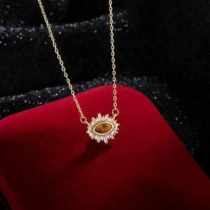 French luxury Evil Eye necklace with tiger eye stone and zircons on red velvet