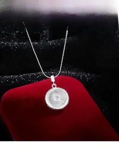 Detailansicht einer silbernen Sonnenanhänger-Halskette mit Zirkonia in einer Geschenkbox