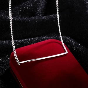 Elegant silver smile bar necklace displayed on a red velvet jewelry gift box