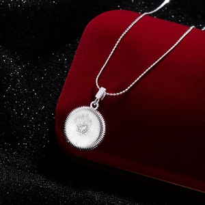 Elegante Silberkette mit Sonnenstrahl-Anhänger auf dunklem Samt, schicker geometrischer Stil