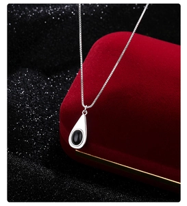Detalle del colgante de ágata negra en forma de gota con cadena de caja de plata brillante