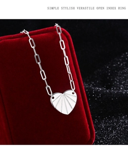 Dettaglio del ciondolo a cuore argento con catena a graffetta su scatola rossa