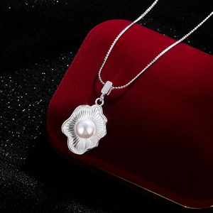 Elegant shell pendant necklace with white pearl on twisted chain over velvet box