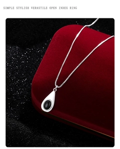 Detalle del colgante de gota con piedra de ónix negro en una fina cadena de plata