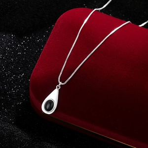 Collar minimalista de plata con colgante de gota en ágata negra sobre caja de terciopelo