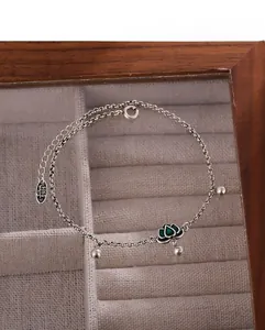 Detail of S925 silver anklet with green enamel lotus flower and engraved hallmark
