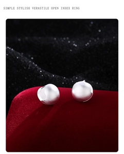 Macro view of minimalist matte silver ball rings on luxury dark velvet display