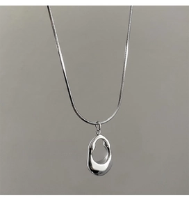 Macro view of silver organic irregular hollow oval pendant with shiny snake chain