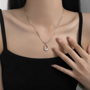 Minimalist silver irregular hollow oval necklace with snake chain worn by a female model
