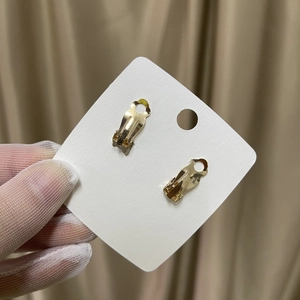 Handmade gold flower bridal clip-on earrings with spring back closure on white card