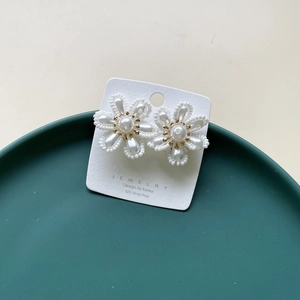Close-up of handmade bridal flower earrings with pearls and 925 silver posts
