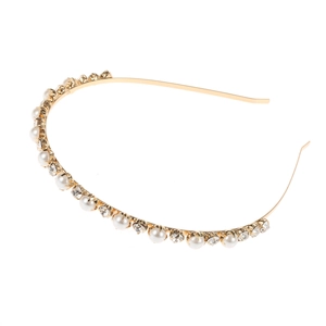 Elegante cerchietto dorato con perle bianche e strass scintillanti su uno sfondo bianco