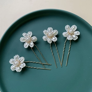 Set of 4 handmade bridal hair pins featuring white faux pearl flowers on gold metal waves