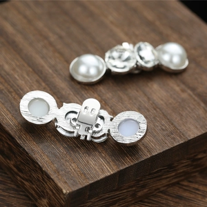 Close-up of sparkling rhinestone and pearl shoe clips with metal spring buckles