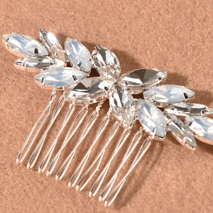 Macro detail of silver hair comb featuring marquise-cut opal stones and clear crystals