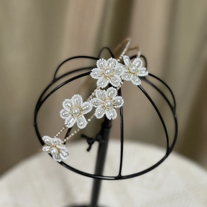 Detail of handmade beaded flower headband with pearls for bridal wedding hairstyles
