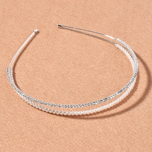 Double-row silver headband featuring white pearls and sparkling rhinestones on a tan base