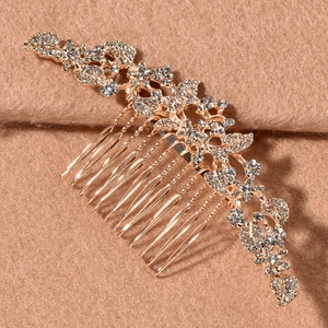 Detailed close-up of vintage golden bridal hair comb with intricate rhinestones and leaf patterns
