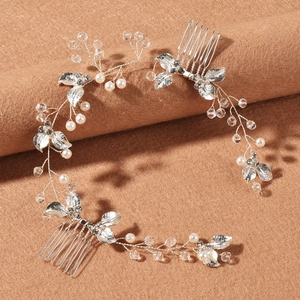 Detail of silver bridal hair vine with pearls, crystals, and metallic leaves on combs