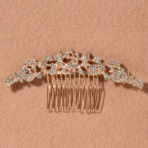 Detailed macro view of luxury gold bridal hair comb with rhinestone floral leaves