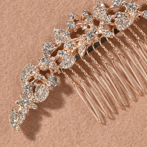 Macro detail of luxury gold bridal hair comb with vintage rhinestone leaf patterns