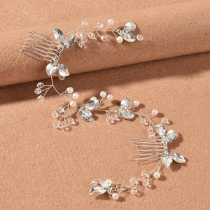 Detail of silver bridal hair comb with white pearls and sparkling leaf rhinestones
