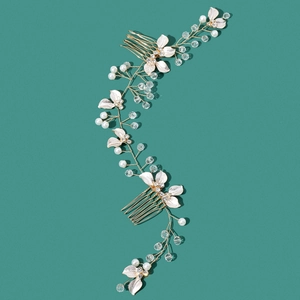 Detail showing bridal hair vine with gold wire leaves and pearls on green background