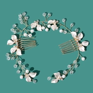 Detail of bridal hair comb with gold leaves, white pearls and sparkling rhinestones