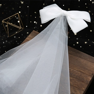 Elegante velo da sposa con fiocco di raso bianco e tulle su uno sfondo romantico