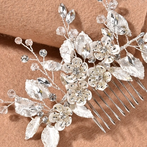 Macro view of bridal hair comb with silver leaves, white flowers and marquise crystals