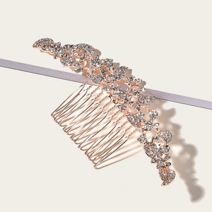 Macro detail of rose gold bridal hair comb with intricate rhinestone flower design