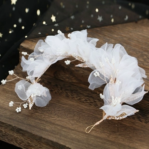 Détail de la pince à cheveux de mariée avec fleurs en dentelle et feuilles dorées