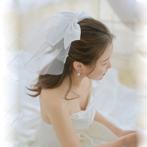 Elegante velo da sposa corto con grande fiocco di raso e perle su una rete sottile
