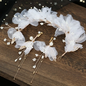 Détail d'un peigne à cheveux et boucles d'oreilles de mariée avec fleurs en tulle blanc