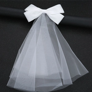 Dettaglio dell'elegante fiocco di raso bianco con velo da sposa su sfondo nero opaco