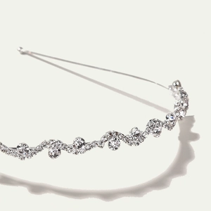 Elegant wavy silver bridal headband with sparkling rhinestones and crystal accents