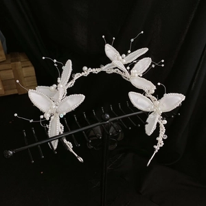 Détail d'un serre-tête de mariée avec feuilles de satin blanc et perles sur support