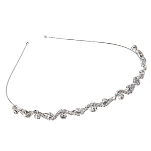 Detailed close-up of wavy silver headband with sparkling rhinestones and crystal inlay