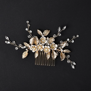 Golden bridal hair comb with white enamel flowers, marquise crystals, and metallic leaves