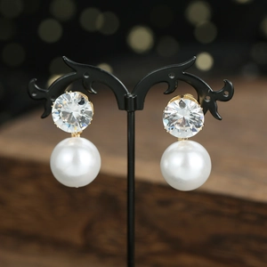 Elegant bridal zircon drop earrings with large round pearls on vintage display stand