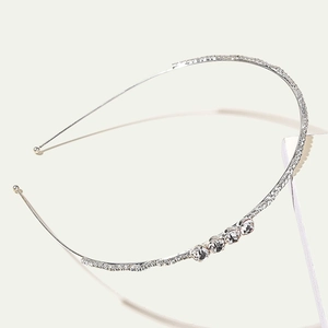 Detailed close-up of a silver rhinestone headband with crystal accents for wedding hair