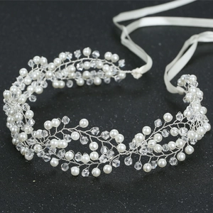 Elegant bridal hair vine with crystal pearls and silver wire on a black background