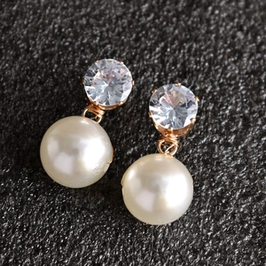 Detail van elegante bruidsoorbellen met grote ronde parels en fonkelende zirkonia's