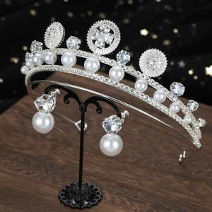 Detail view of luxury silver bridal tiara and earrings set with pearls and crystals