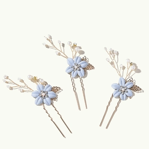 Détails de trois épingles à cheveux fleurs bleues avec perles et feuilles dorées