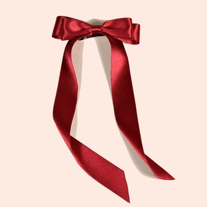 Elegant deep red satin bow hair clip with long flowing ribbons for wedding bridal hair styling