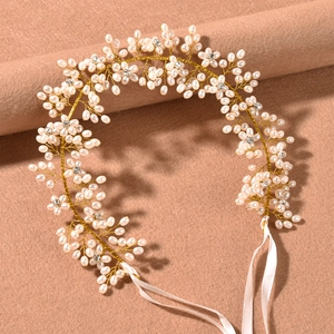 Close-up of handmade bridal headband with white pearls, rhinestones and silk ribbons